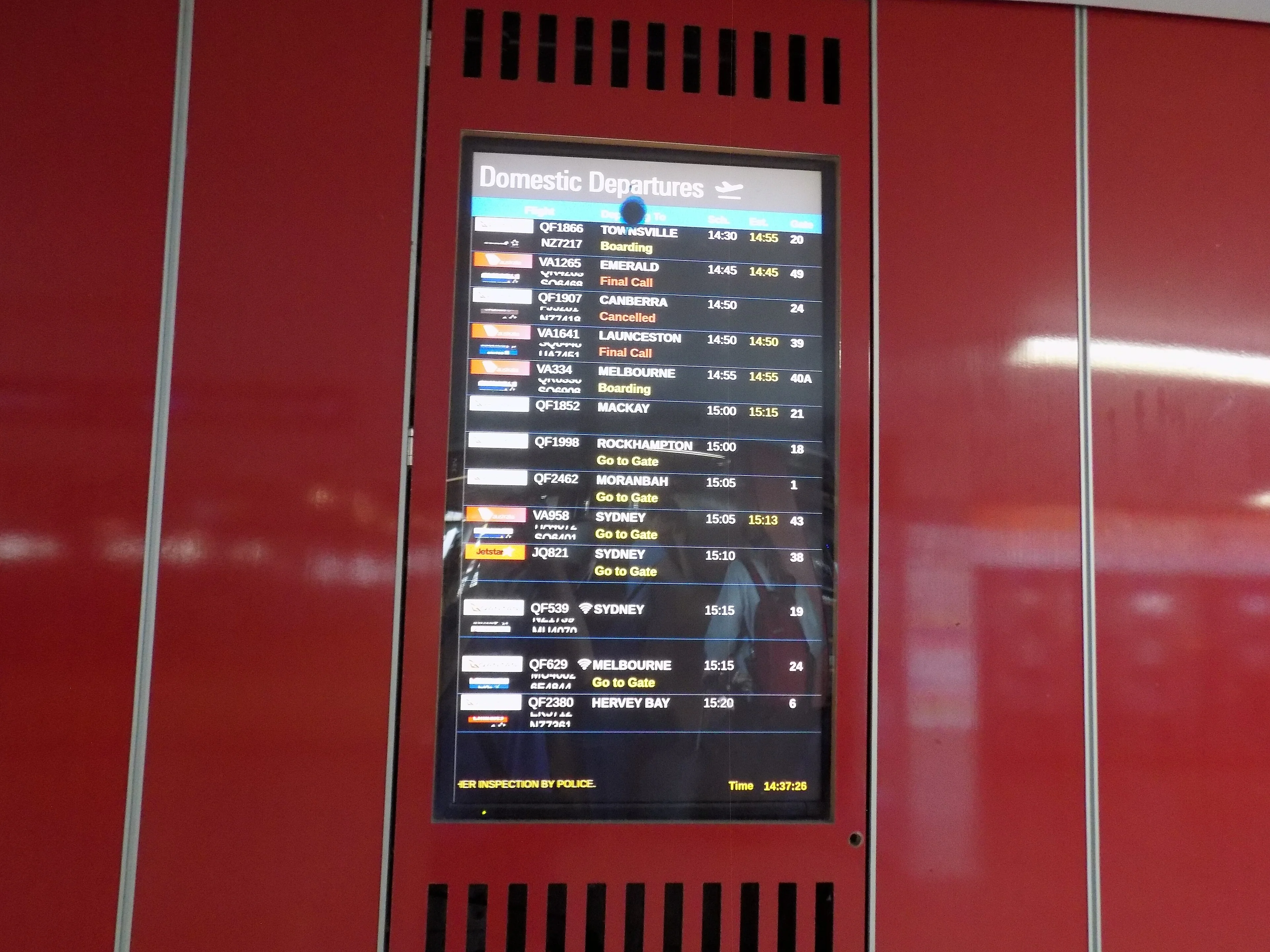 Viajantes e painel de voos em aeroporto internacional europeu