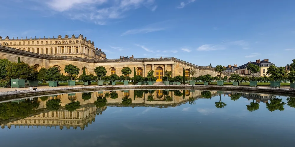 Fachada dourada e jardins monumentais do Palácio de Versalhes